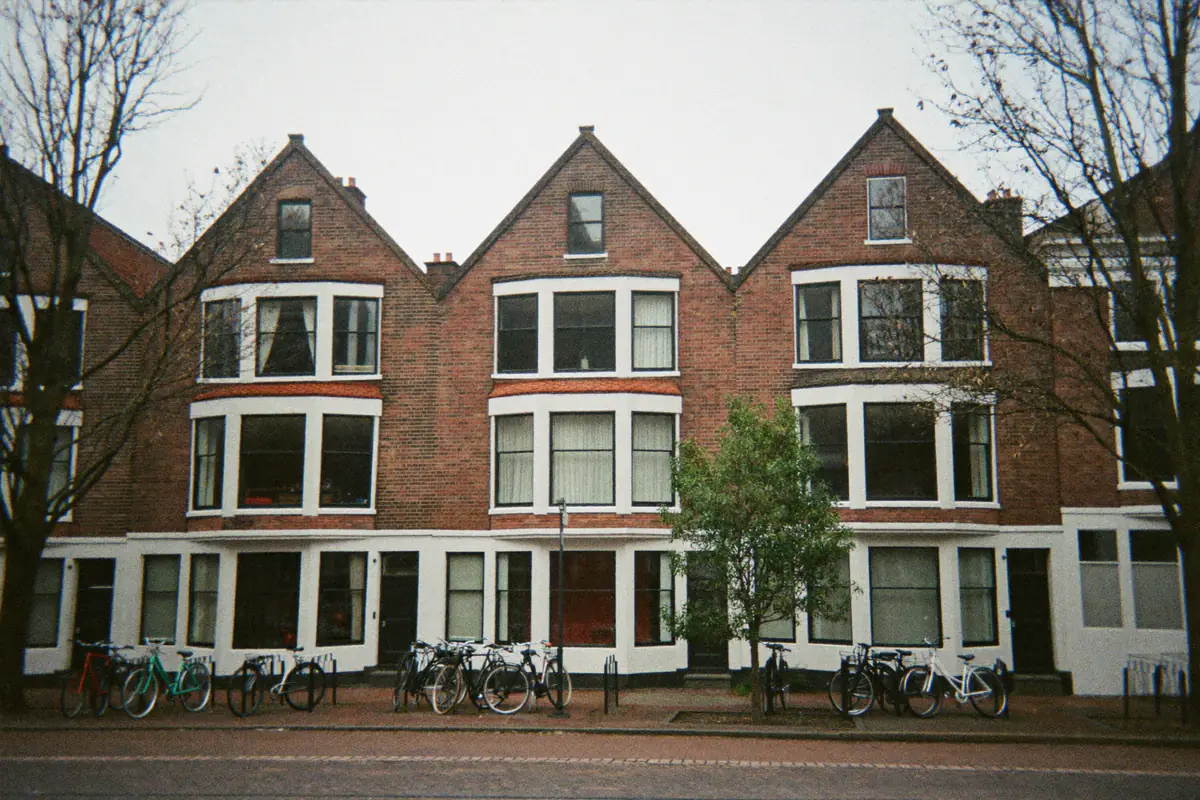 Rij bakstenen woningen met erkers en fietsen voor de deur
